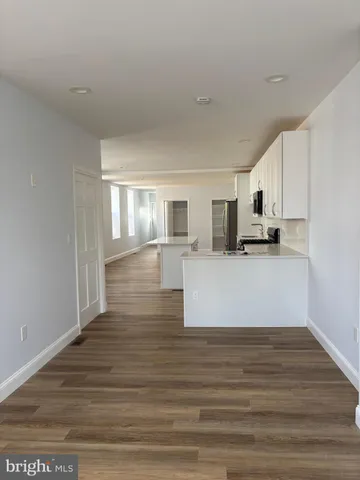 a view of a kitchen with wooden floor and electronic appliances
