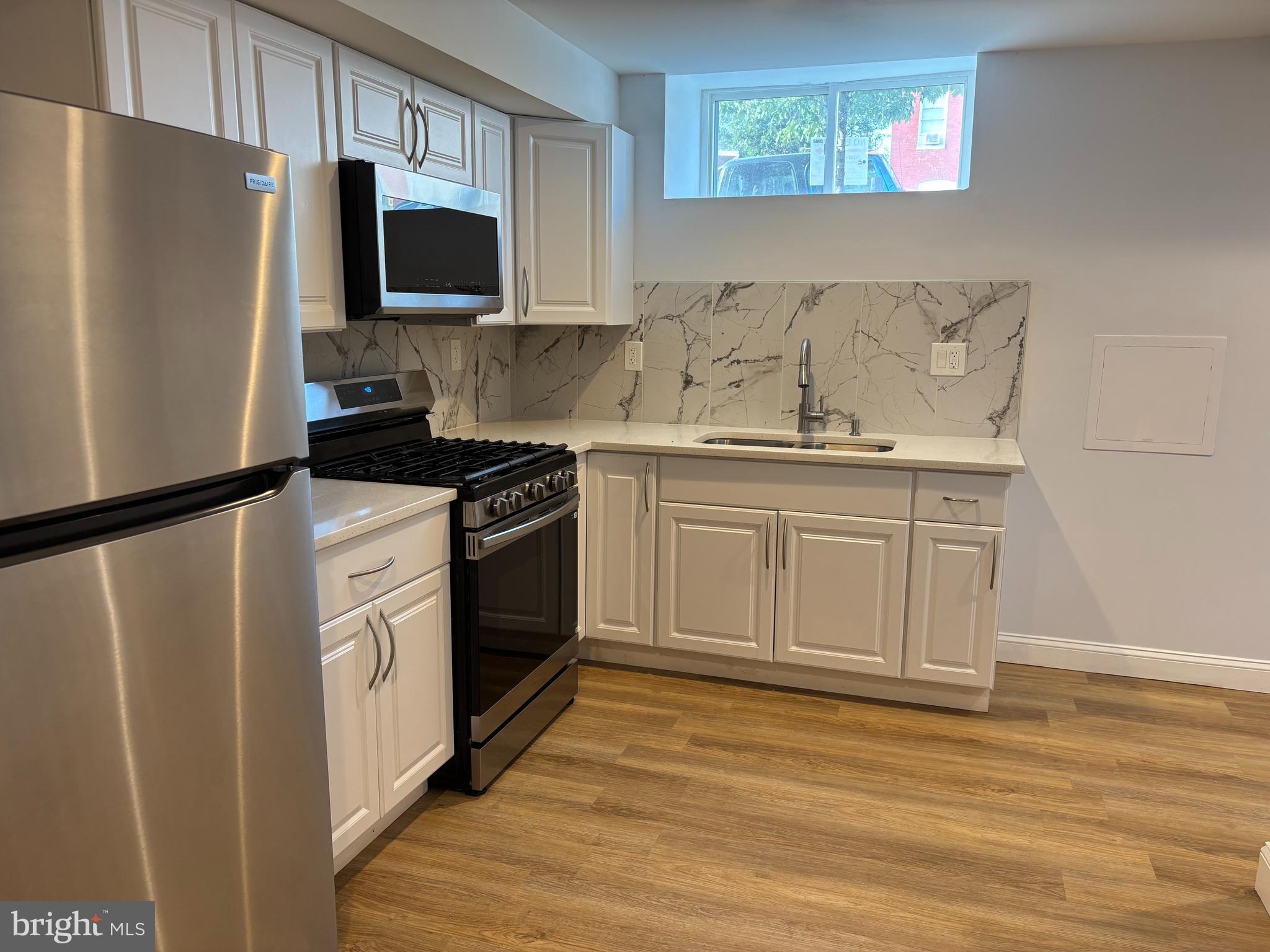 2505 Federal Street Baltimore, MD 21213 - Photo 21 of 26 a kitchen with stainless steel appliances a stove microwave and refrigerator