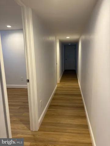 a view of a hallway with wooden floor and stairs