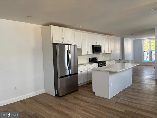 a kitchen with stainless steel appliances a refrigerator and a stove top oven