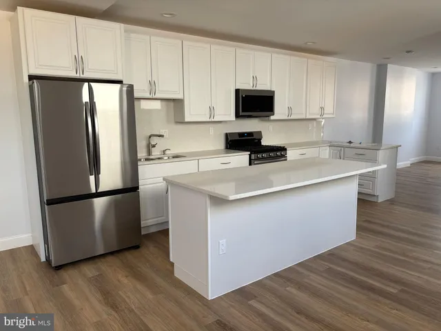 a kitchen with a refrigerator sink and cabinets