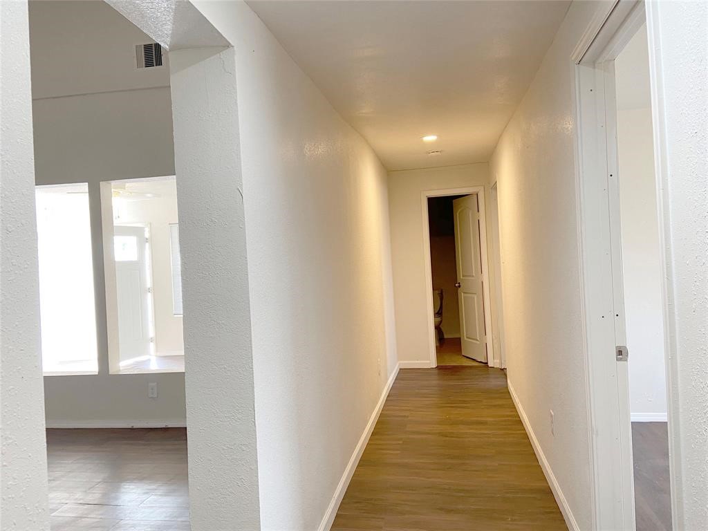 12115 Segrest Drive Houston, TX 77047 - Photo 2 of 13 a view of a hallway with wooden floor and a bathroom