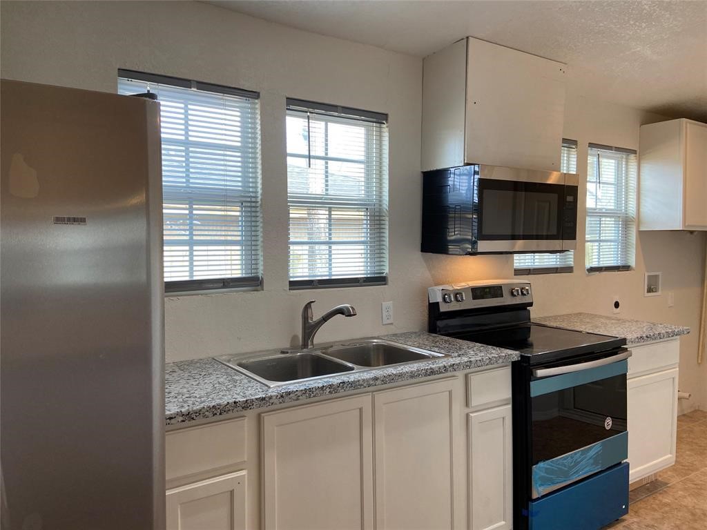 12115 Segrest Drive Houston, TX 77047 - Photo 8 of 13 a kitchen with granite countertop a sink and a stove top oven