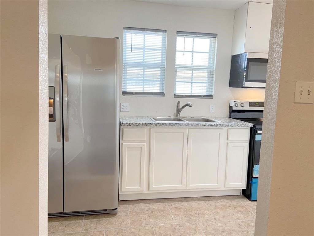 12115 Segrest Drive Houston, TX 77047 - Photo 9 of 13 a kitchen with a sink stove and refrigerator