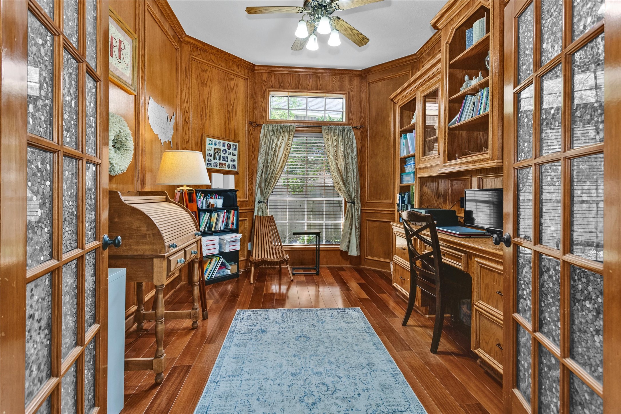 8314 Drew Haven Lane Spring, TX 77379 - Photo 11 of 49 This cozy home office features warm wood paneling, built-in bookshelves, and a large window for natural light.