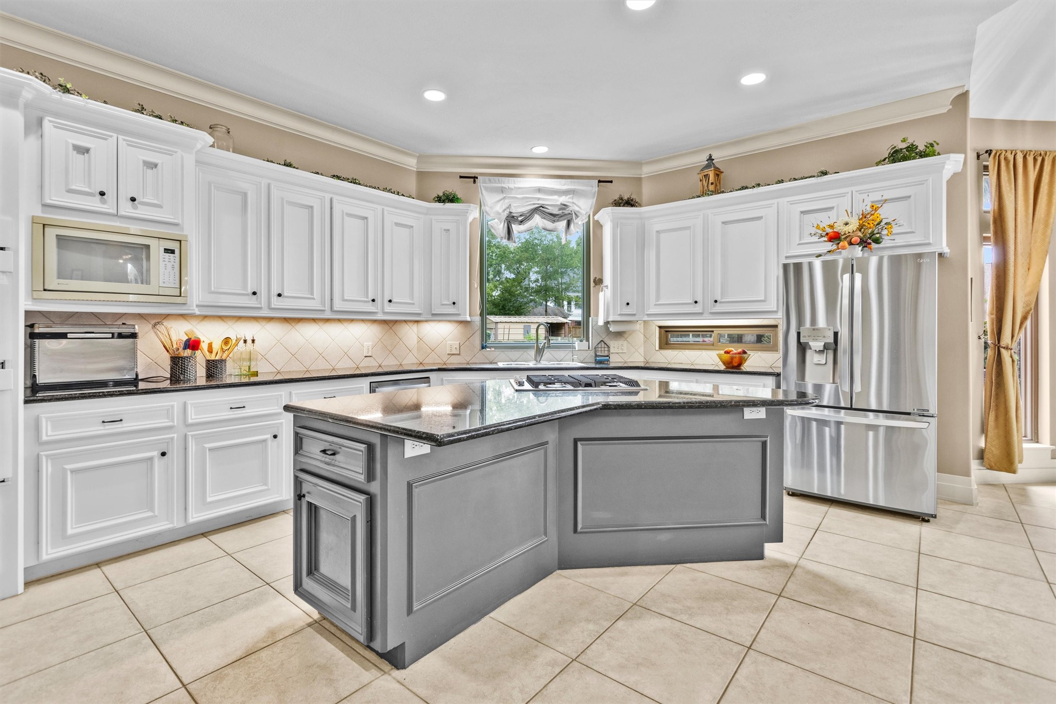 8314 Drew Haven Lane Spring, TX 77379 - Photo 15 of 49 This bright, spacious kitchen features bright white cabinetry, a central island with a cooktop, and stainless steel appliances.