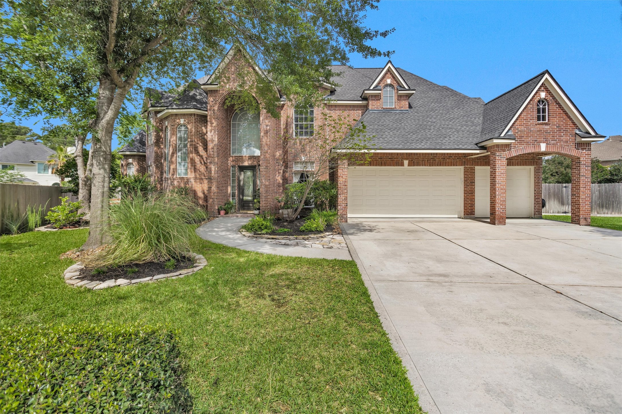 8314 Drew Haven Lane Spring, TX 77379 - Photo 4 of 49 The home has a well-maintained front yard with mature trees and a curved walkway leading to the entrance. The architecture includes large windows, adding elegance and charm.