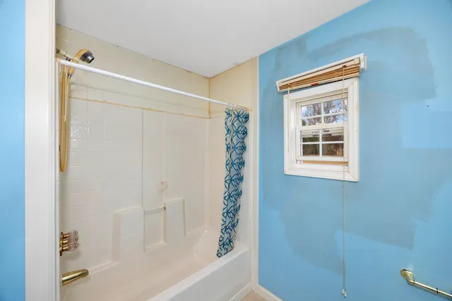a bathroom with a shower curtain and a window
