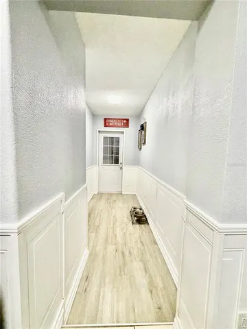 a view of a bedroom with wooden floor and white walls