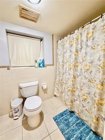 a white toilet sitting next to a shower curtain