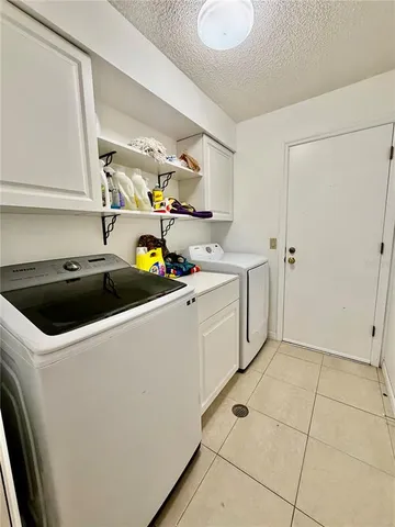 a utility room with cabinets washer and dryer