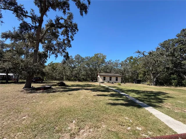 a view of a yard with swimming pool and trees
