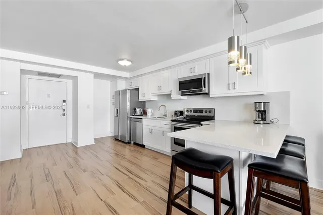 a kitchen with a table chairs refrigerator and microwave