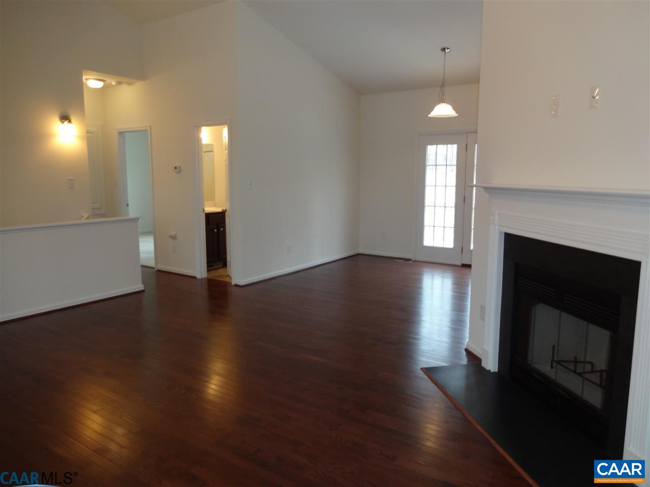301 East Daffodil Road Ruckersville, VA 22968 - Photo 3 of 26 an empty room with wooden floor and fireplace