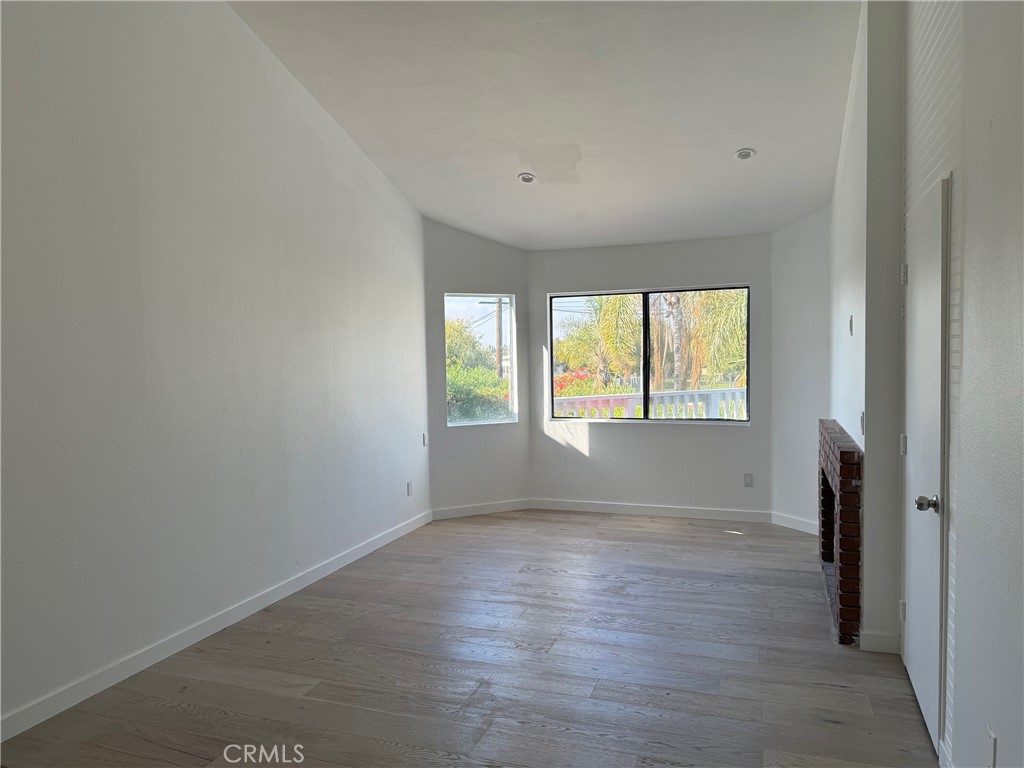 7652 Cerritos Avenue, Unit E Stanton, CA 90680 - Photo 11 of 14 an empty room with wooden floor and windows