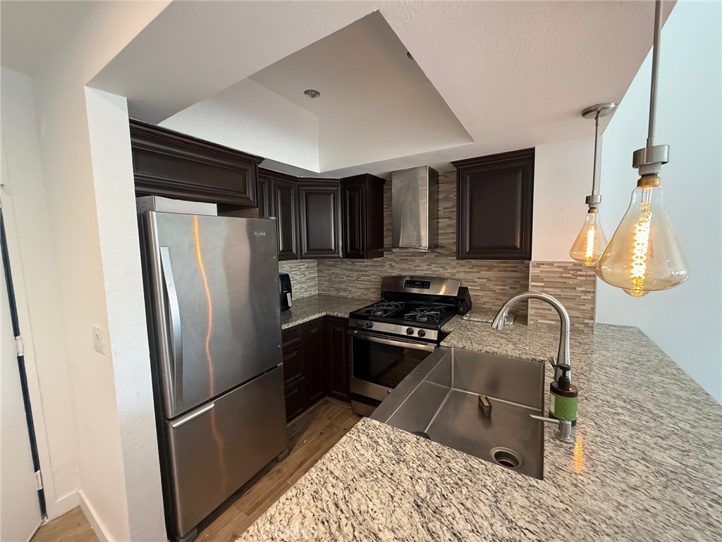 7652 Cerritos Avenue, Unit E Stanton, CA 90680 - Photo 3 of 14 a kitchen with granite countertop a refrigerator stove and sink