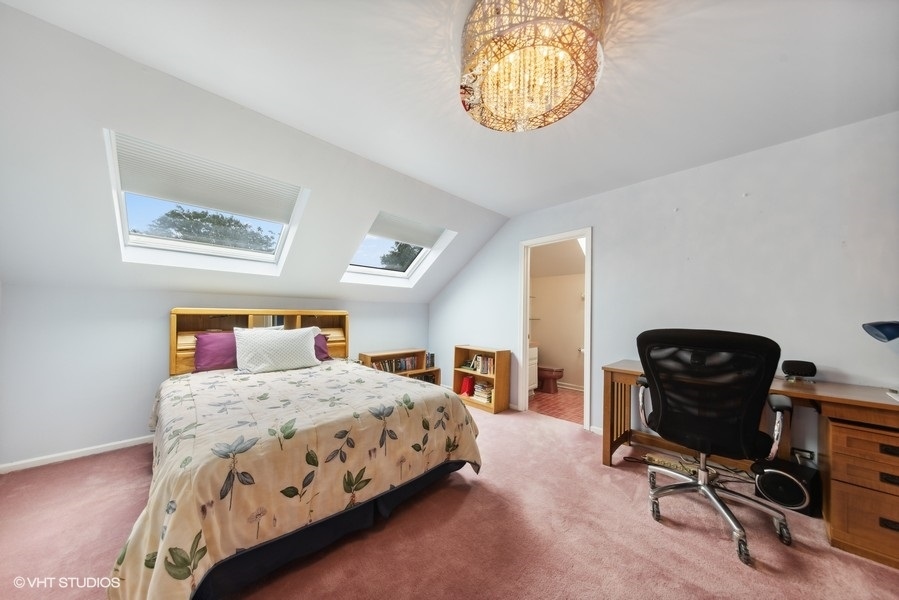 2 Keri Lane Burr Ridge, IL 60527 - Photo 15 of 24 a bedroom with a bed and a chandelier