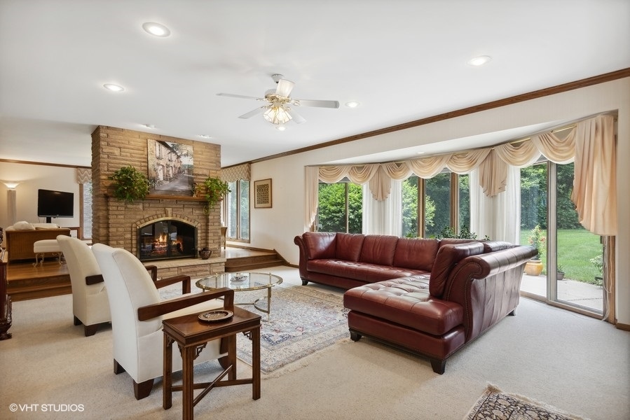 2 Keri Lane Burr Ridge, IL 60527 - Photo 4 of 24 a living room with furniture a fireplace and a floor to ceiling window