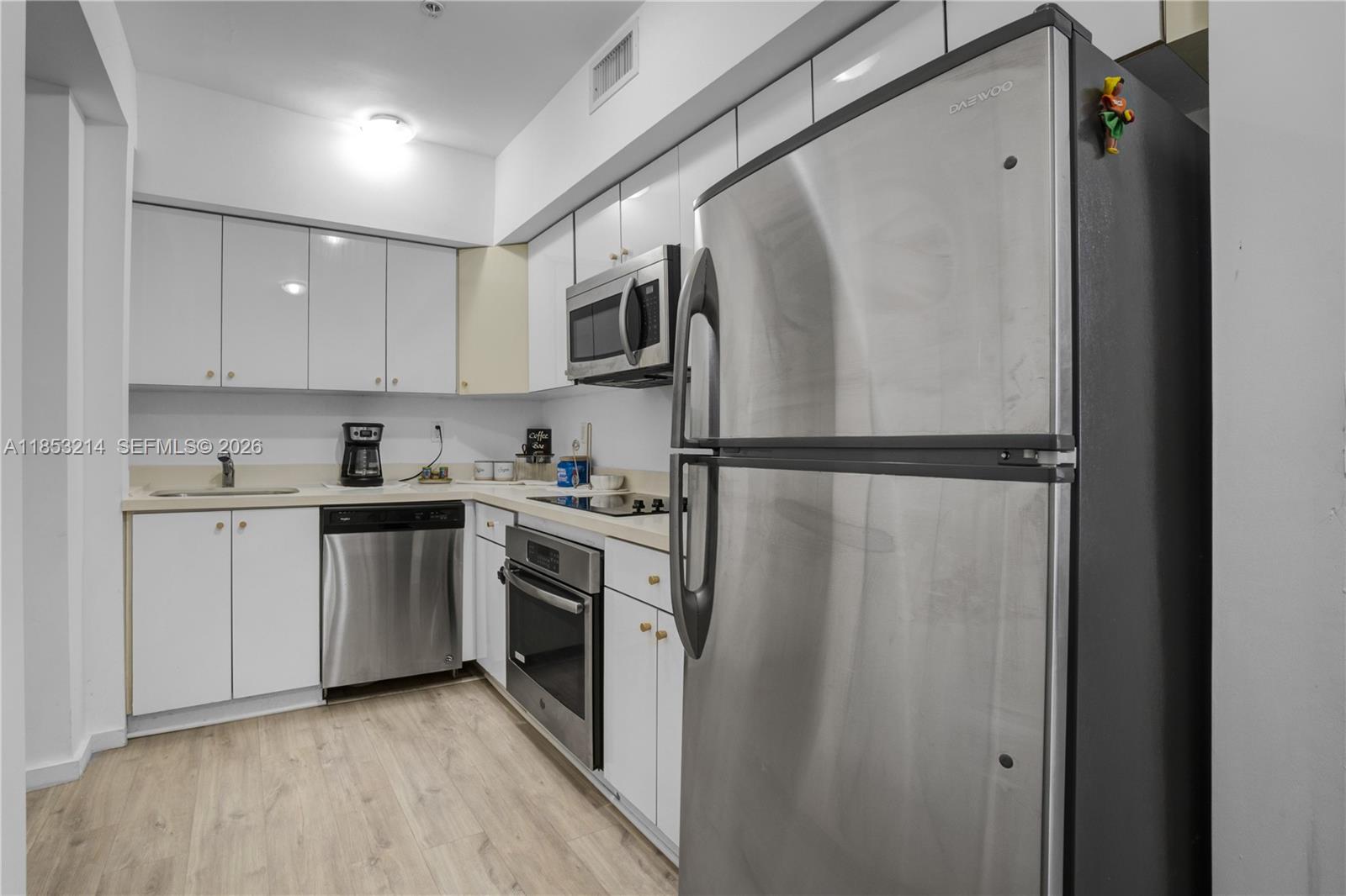 810 7th Street, Unit 107 Miami Beach, FL 33139 - Photo 12 of 36 a kitchen with a refrigerator sink and cabinets