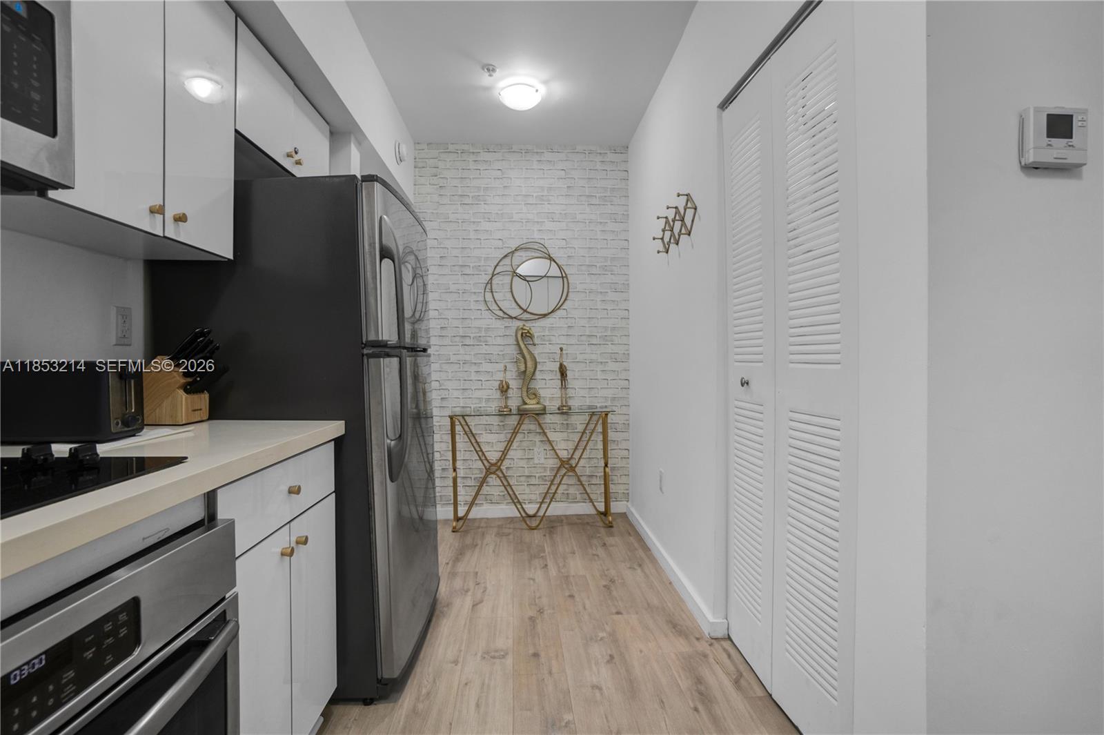 810 7th Street, Unit 107 Miami Beach, FL 33139 - Photo 13 of 36 a kitchen with a refrigerator a stove top oven and cabinets