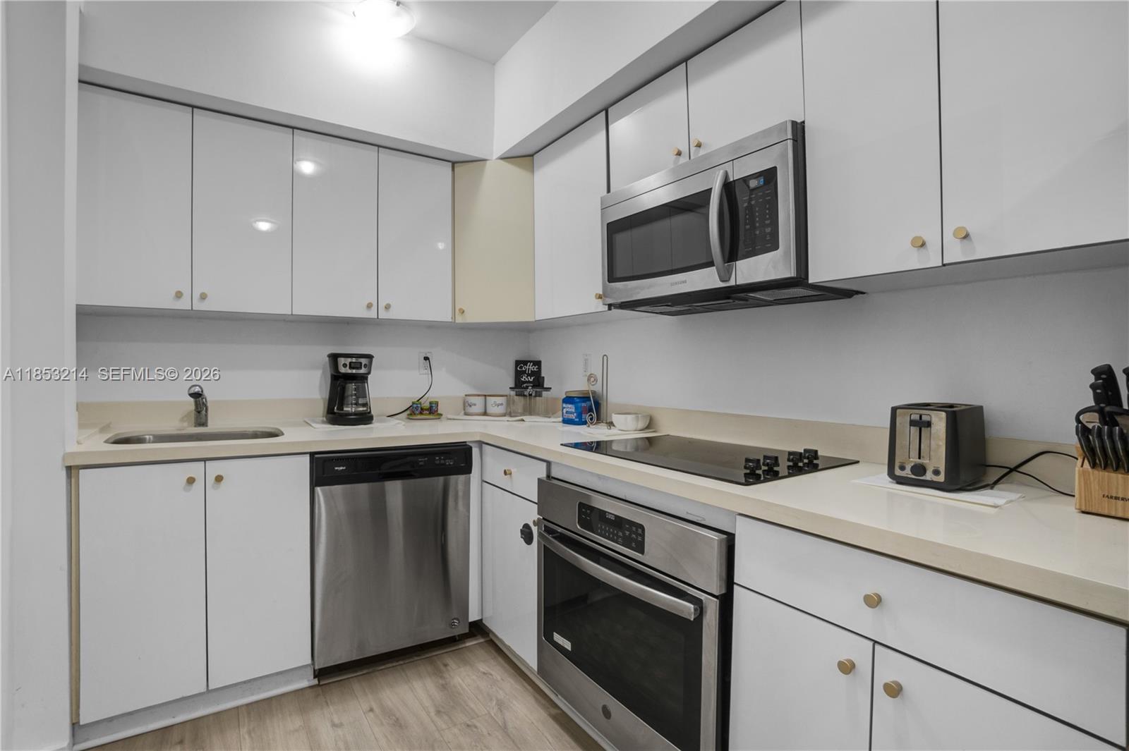 810 7th Street, Unit 107 Miami Beach, FL 33139 - Photo 14 of 36 a kitchen with cabinets stainless steel appliances and sink