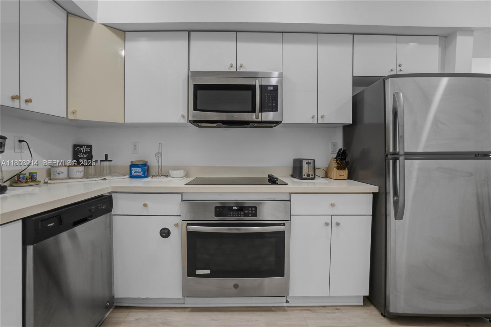 810 7th Street, Unit 107 Miami Beach, FL 33139 - Photo 15 of 36 a kitchen with stainless steel appliances white cabinets white stove a microwave and a refrigerator