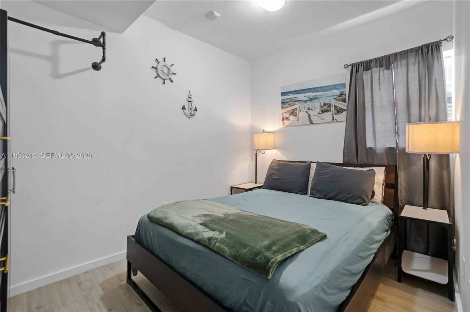 810 7th Street, Unit 107 Miami Beach, FL 33139 - Photo 16 of 36 a bedroom with a bed and dresser with mirror
