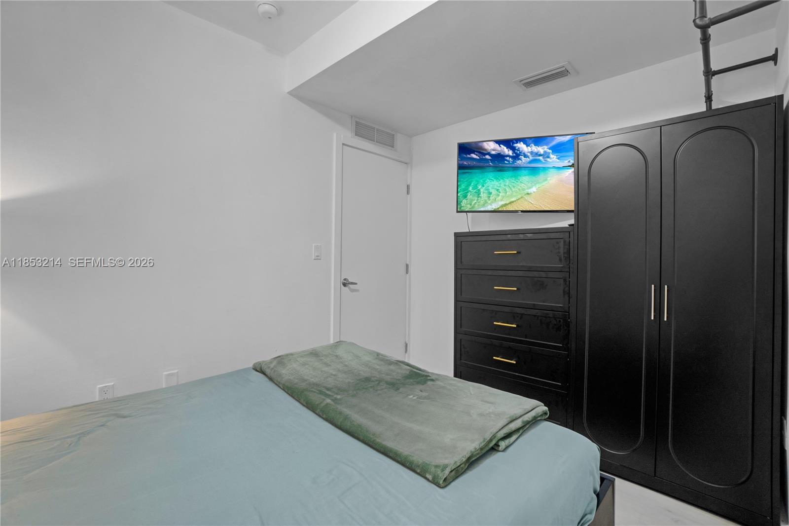 810 7th Street, Unit 107 Miami Beach, FL 33139 - Photo 17 of 36 a bedroom with a bed and a dresser