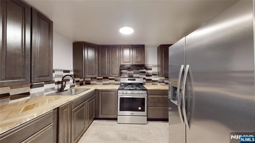 204 Philip Avenue, Unit 2 Elmwood Park, NJ 07407 - Photo 2 of 8 a kitchen with stainless steel appliances granite countertop a sink stove and refrigerator