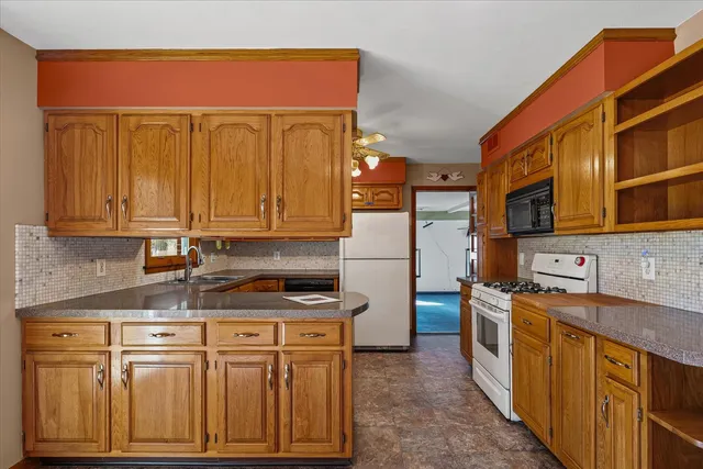 a kitchen with stainless steel appliances granite countertop a stove a sink dishwasher and a refrigerator