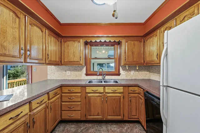 a kitchen with kitchen island granite countertop a sink window and cabinets