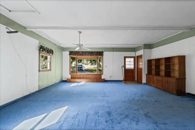 an empty room with windows and chandelier