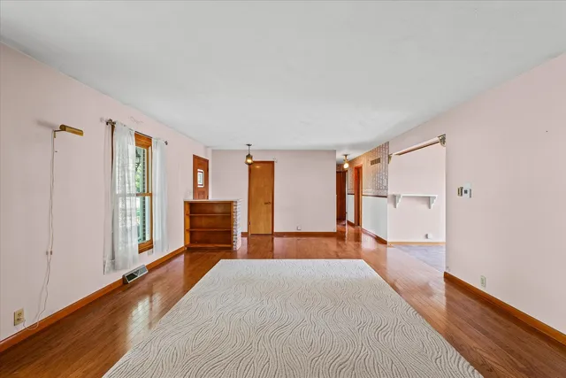 a view of a bedroom with furniture and wooden floor