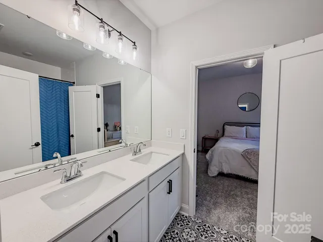 a en suite bathroom with a double vanity sink and a mirror