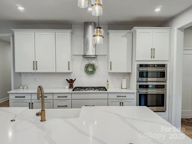 a kitchen with stainless steel appliances kitchen island white cabinets and a sink