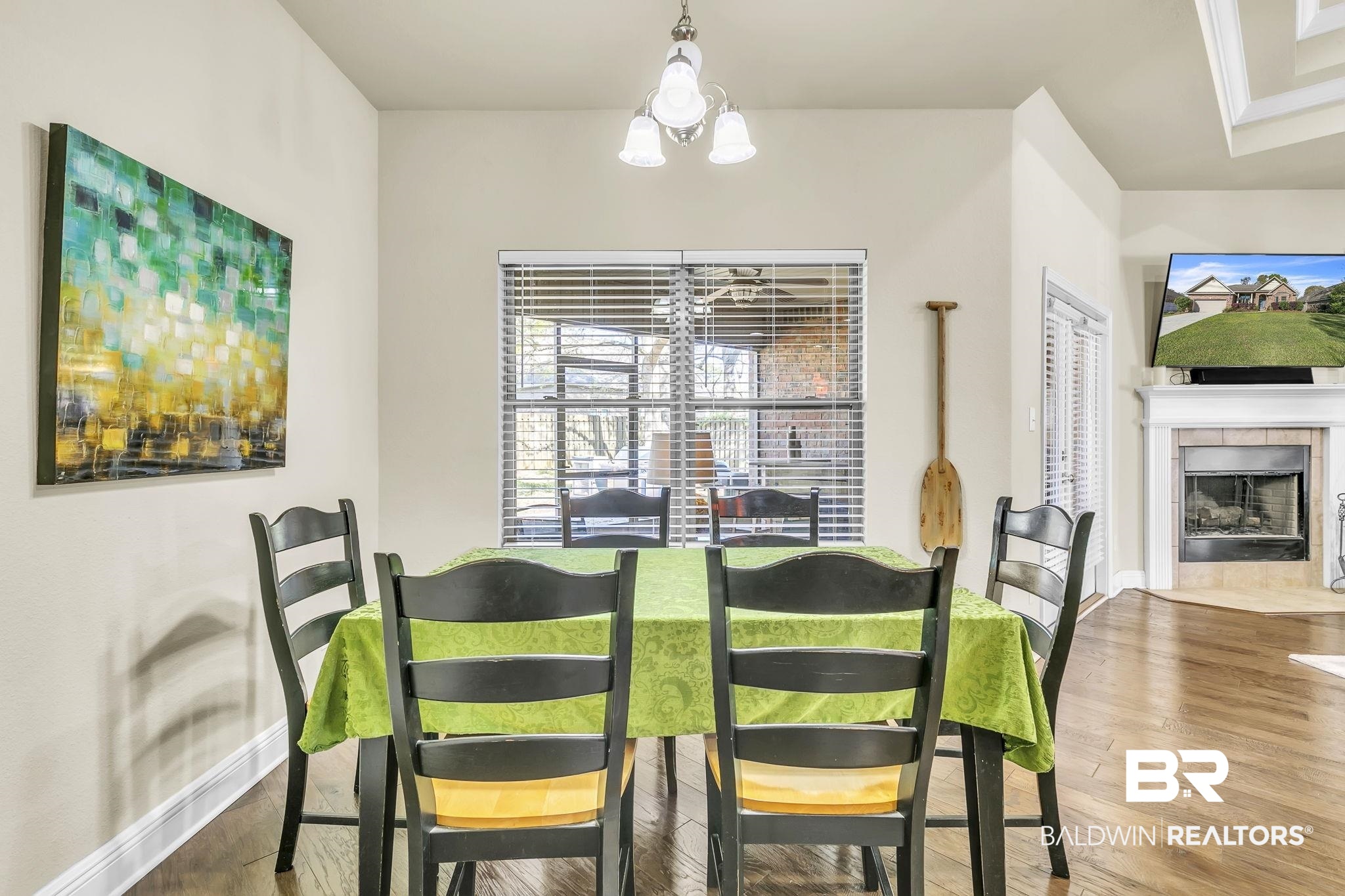 21439 Brick Stack Lane Fairhope, AL 36532 - Photo 11 of 32 Dining space featuring baseboards, wood finished floors, a notable chandelier, and a tile fireplace
