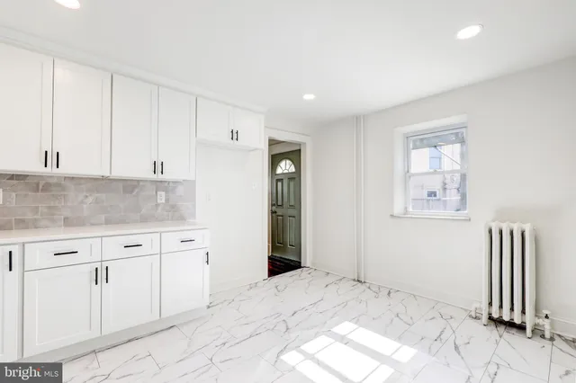 a view of kitchen with granite countertop cabinets