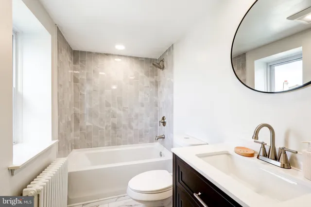 a bathroom with a sink a toilet and a mirror