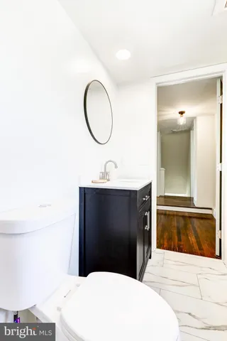 a bathroom with a sink a toilet and a mirror