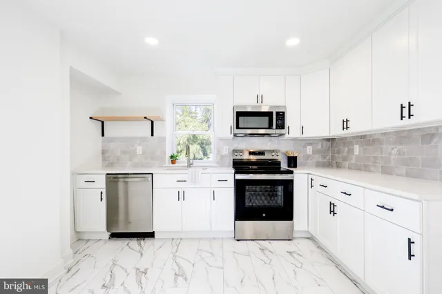 a kitchen with white cabinets and appliances