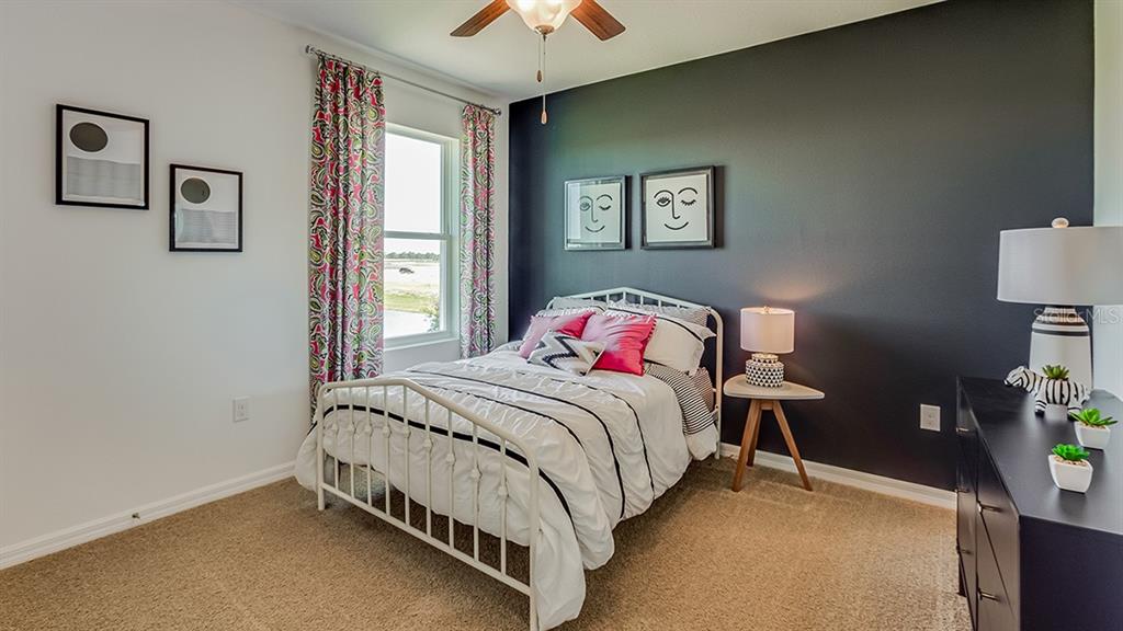 18106 Wheathouse Place Lakewood Ranch, FL 34211 - Photo 13 of 43 a bedroom with a bed and a chandelier