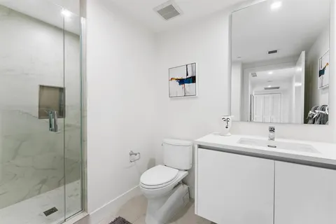 a bathroom with a sink a toilet and shower