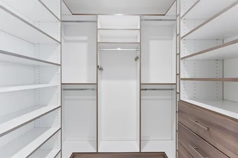 a view of walk in closet with empty racks