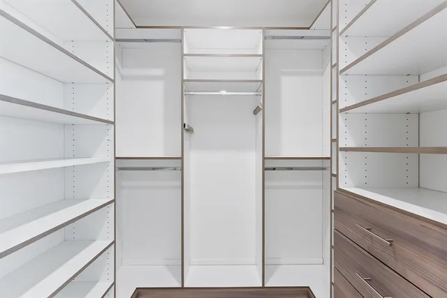 a view of walk in closet with empty racks