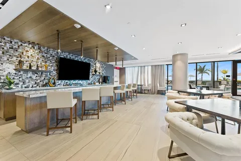 a living room with couches a flat screen tv and kitchen view