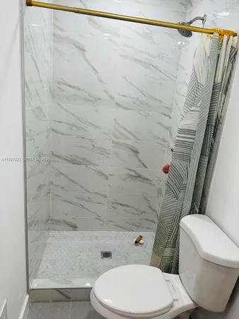 a white toilet and shower curtain