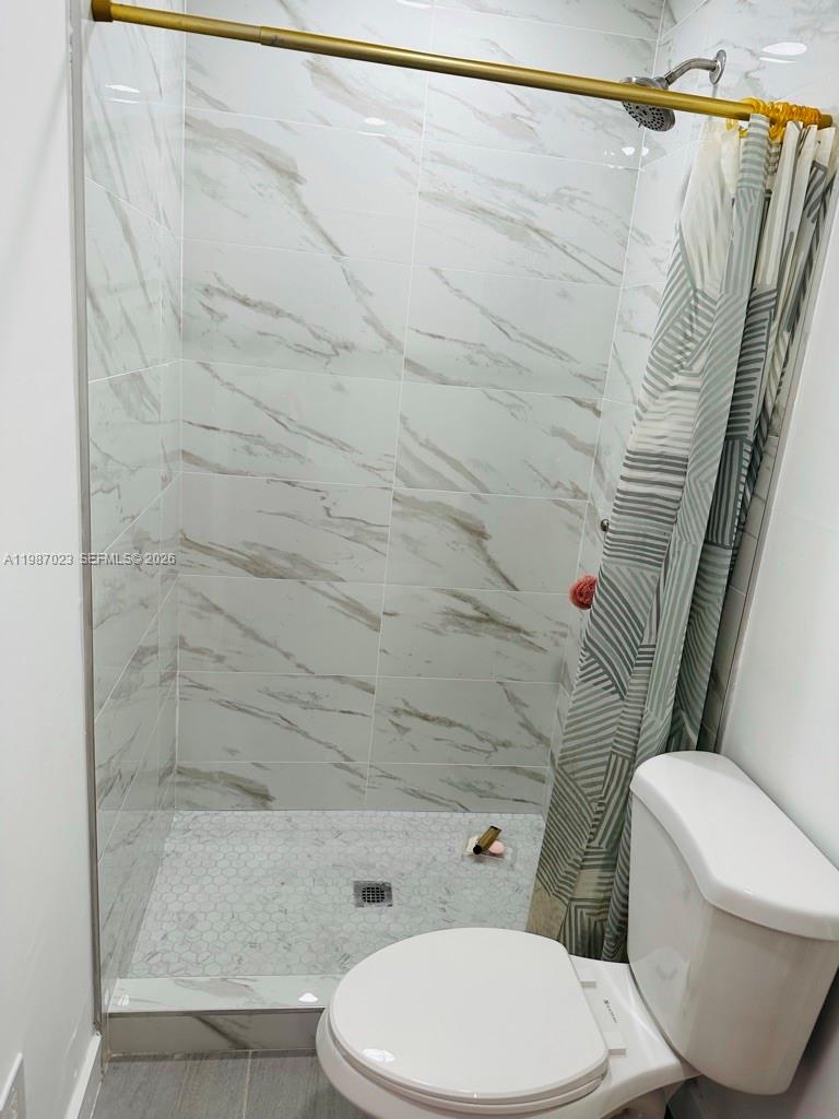 5705 Southwest 39th Street Miami, FL 33155 - Photo 15 of 26 a white toilet and shower curtain