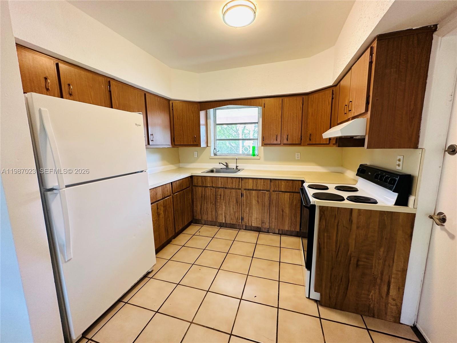 5705 Southwest 39th Street Miami, FL 33155 - Photo 3 of 26 a kitchen with stainless steel appliances granite countertop a refrigerator sink and cabinets