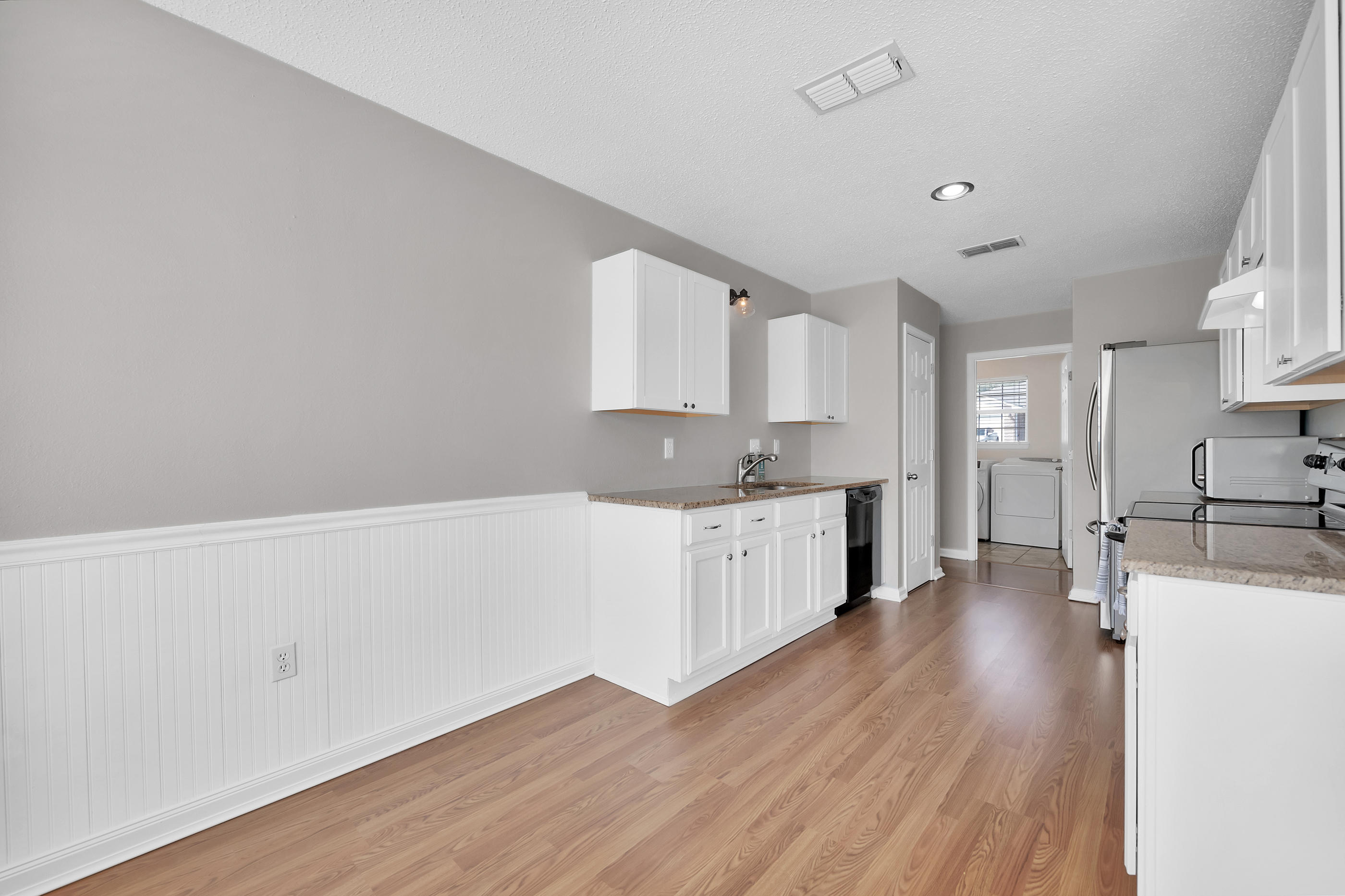139 Sandstone Trail Crestview, FL 32539 - Photo 14 of 36 a kitchen with wooden floors and white cabinets