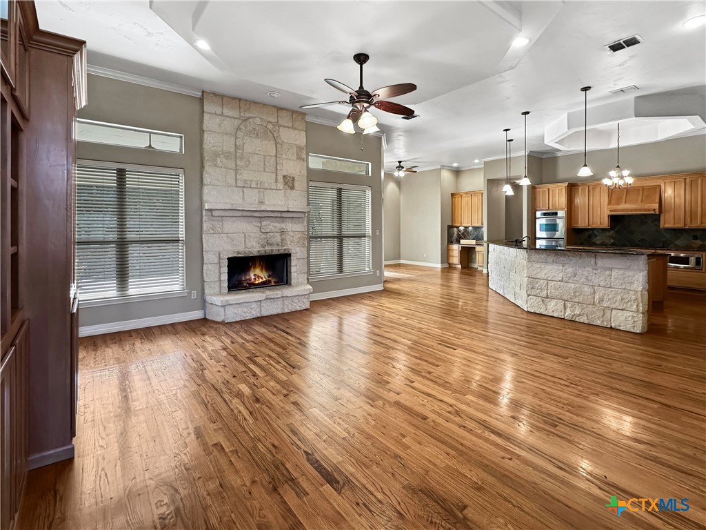 386 Wentworth Spring Branch, TX 78070 - Photo 4 of 39 an open kitchen with granite countertop wooden floors and a fireplace